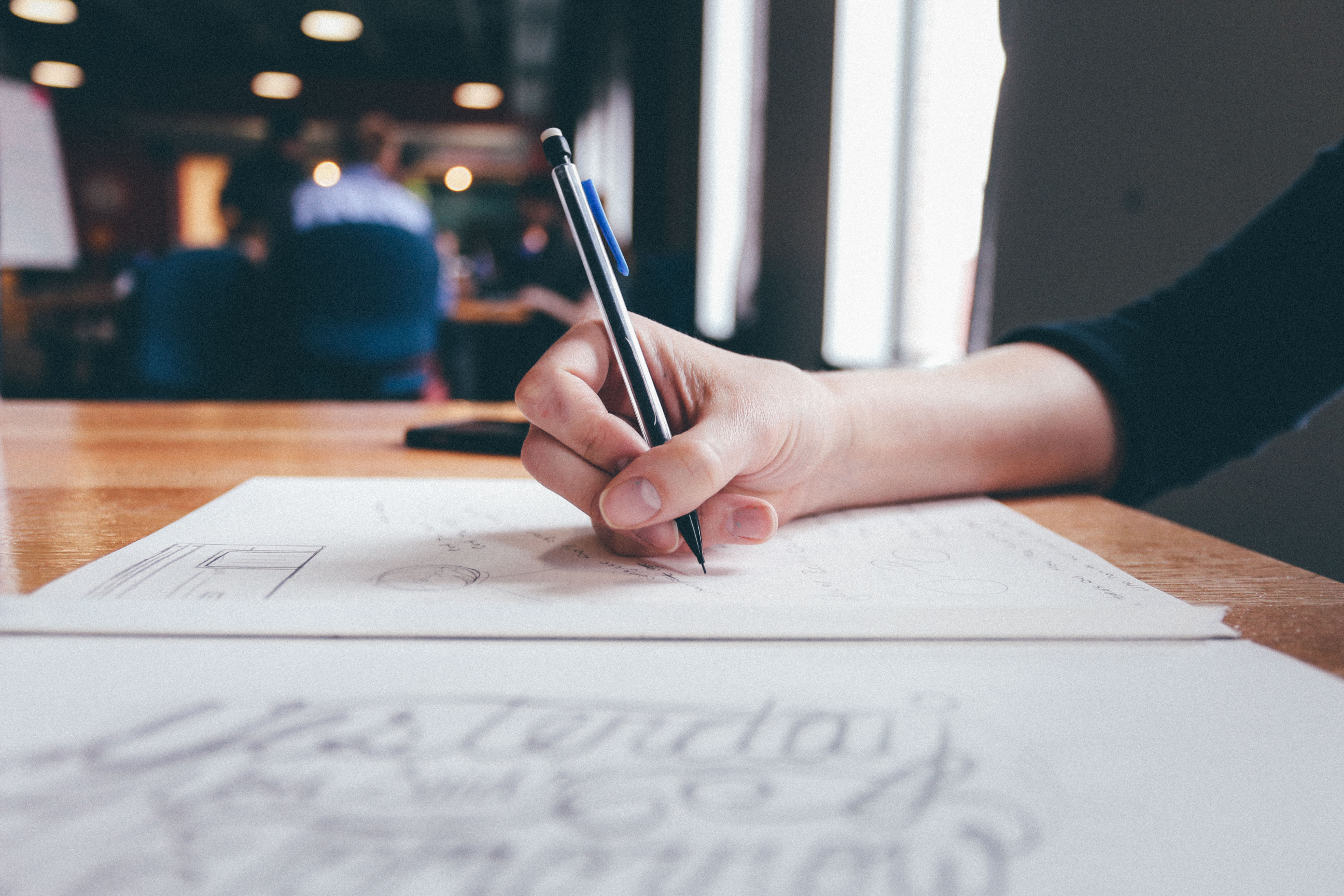 Woman taking notes to reminder herself to follow up with her influencer list she reached out to. 