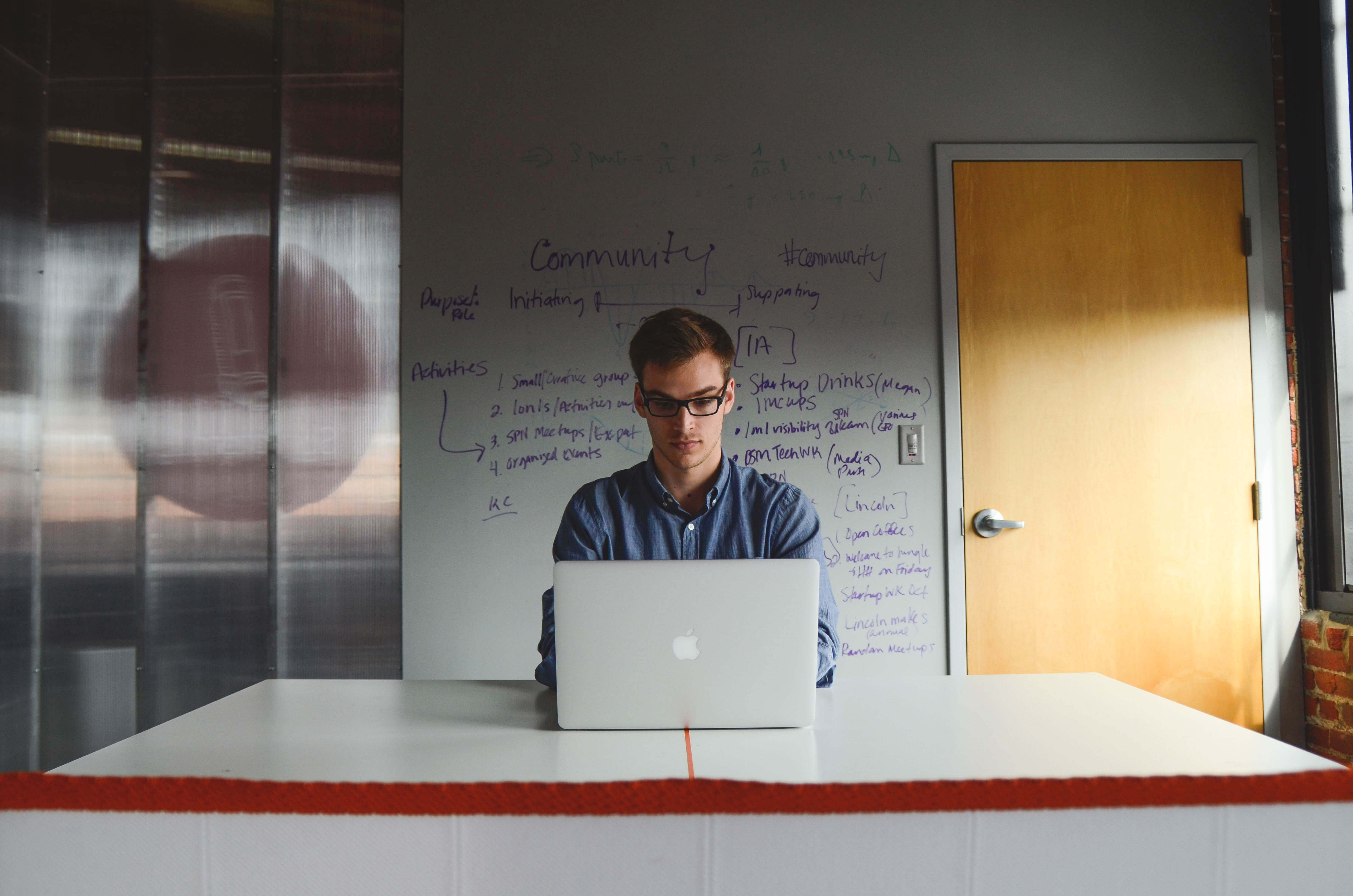 Young man discovering who his audience is and search communities for influencers on a mac