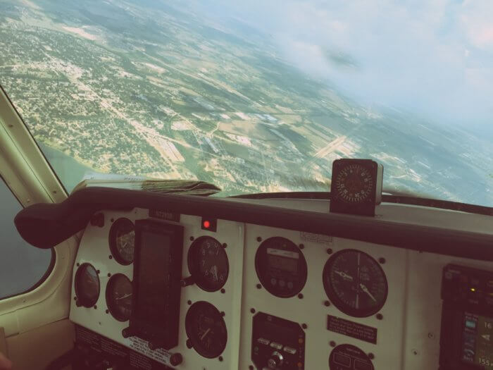 Data mistakes can be avoided with a strong dashboard, like this plane's dashboard and controls with a verdant landscape