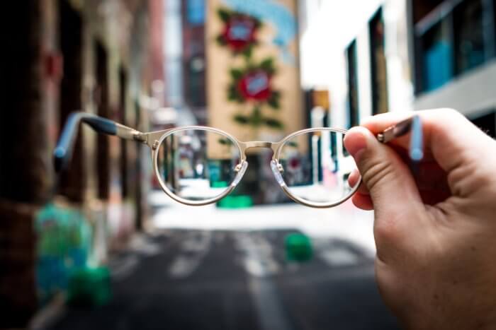 Glasses in the foreground with tall buildings in the background