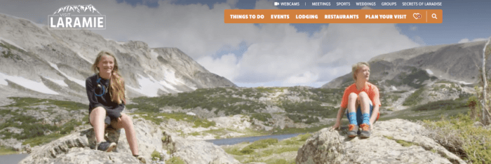 Hikers sitting in the foreground with tall mountains in the background is a great example of travel social media