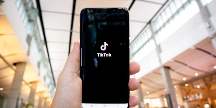 Person holding phone with TikTok on the screen