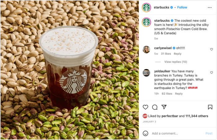 Product shot of a cup of Pistachio Cream Cold Brew on a background of shelled and unshelled pistachios. 